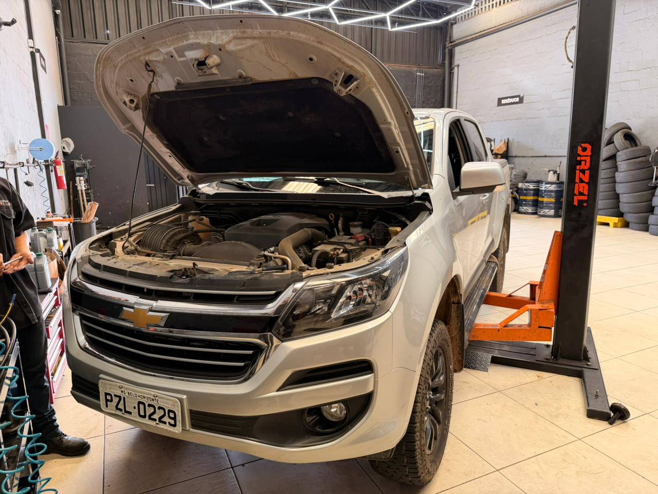 Mecânico examinando motor diesel moderno em oficina limpa e iluminada